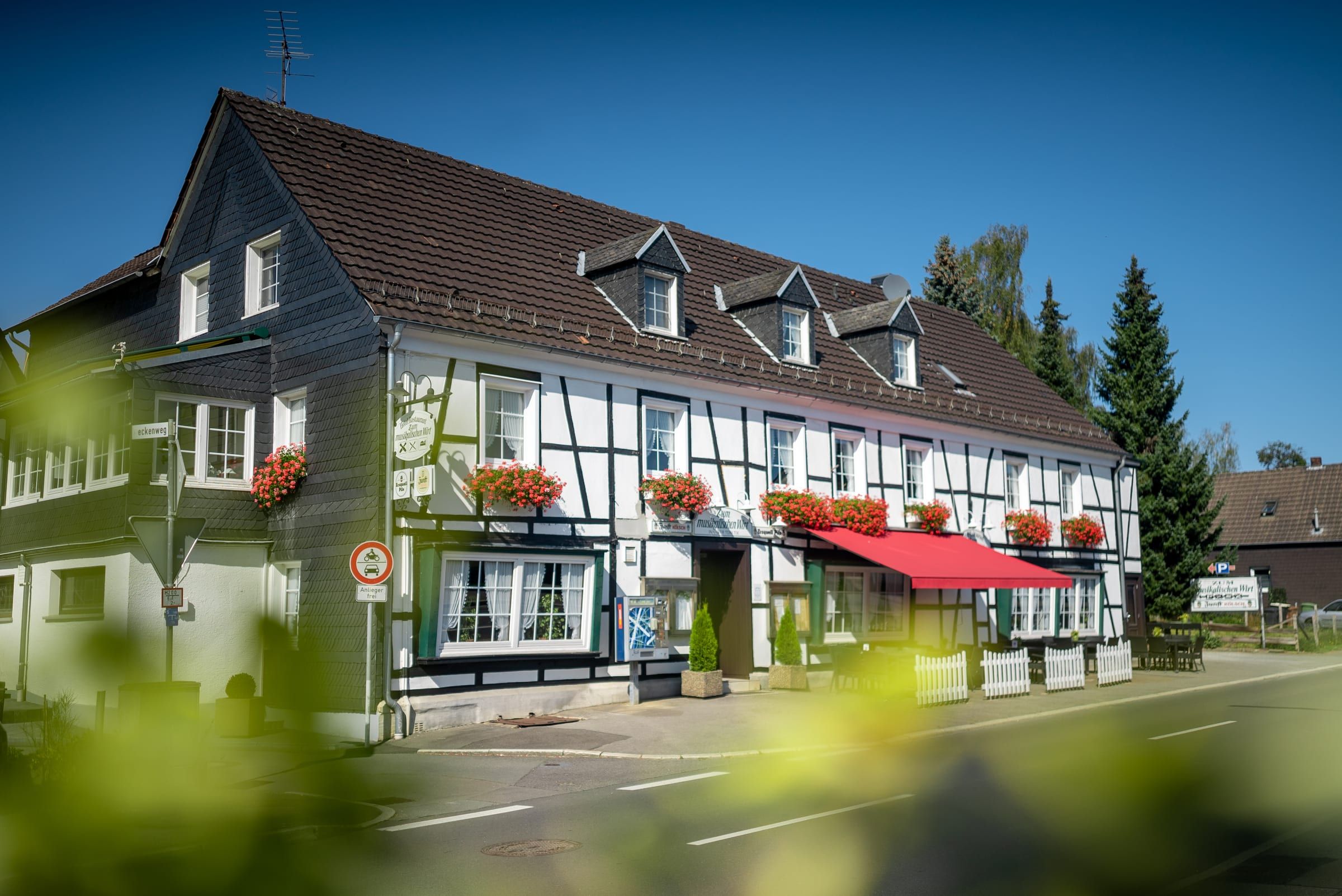 Das Haus von der Straßenecke aus gesehen, mit Parkplatz davor